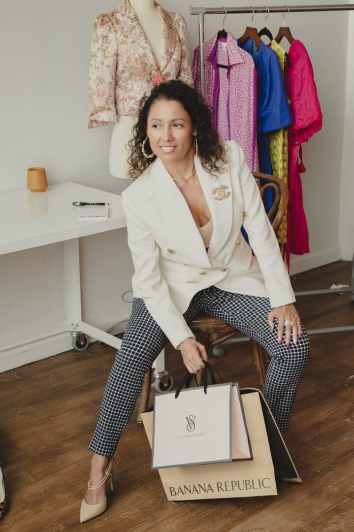 A woman sitting on top of a chair holding onto some bags